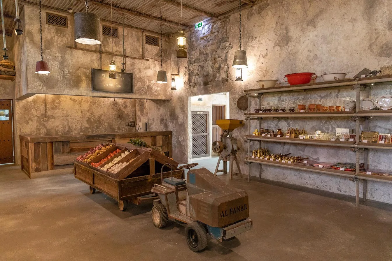 A wooden cart and shelves of goods at the Al Barsha branch