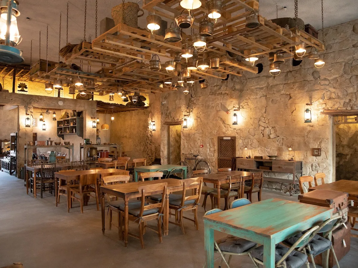 The Al Barsha branch: a dining room with stone walls and lanterns hung from a wooden lattice ceiling