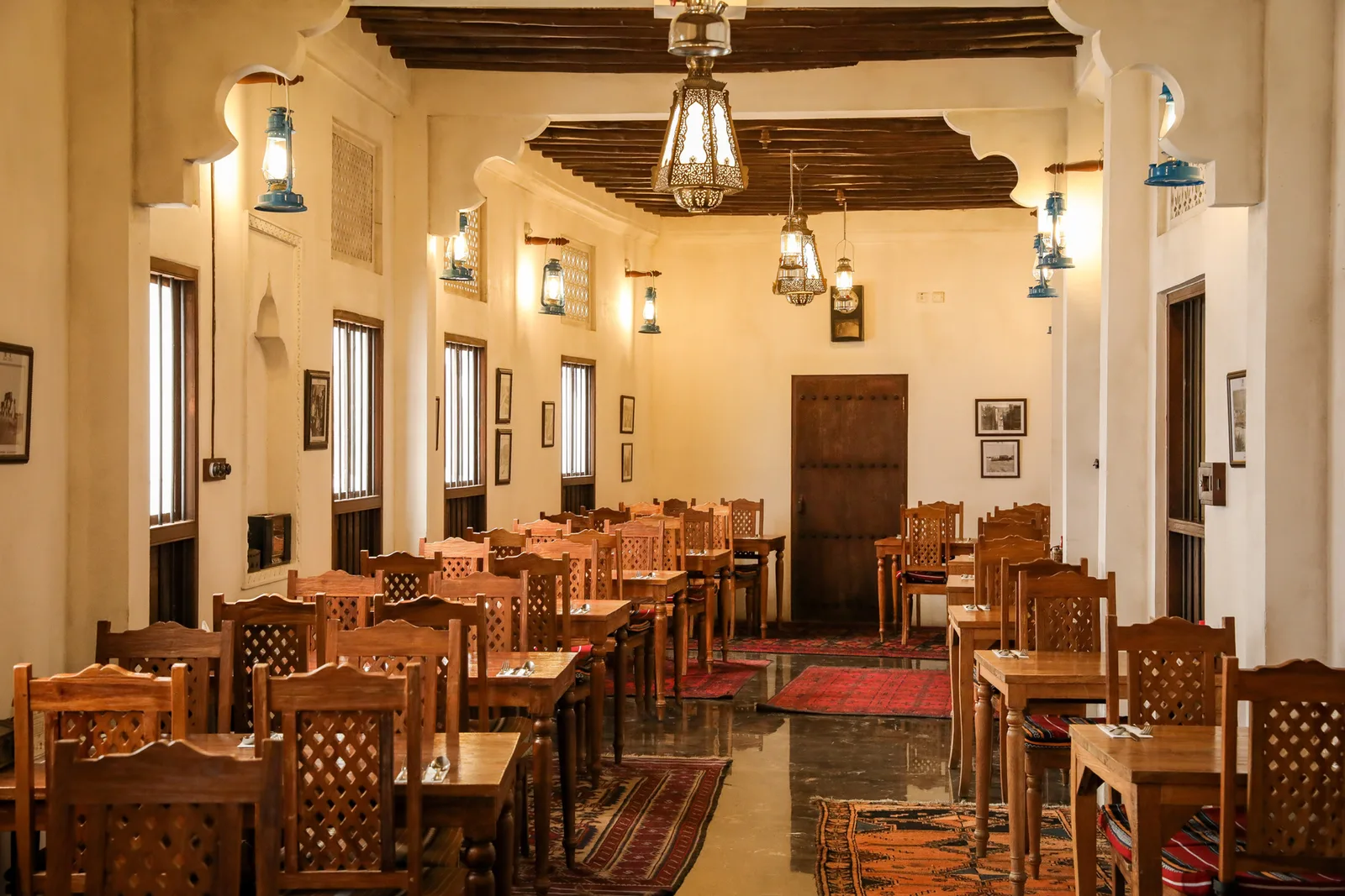 A dining room at Al Fanar with lanterns and a wooden-beam ceiling
